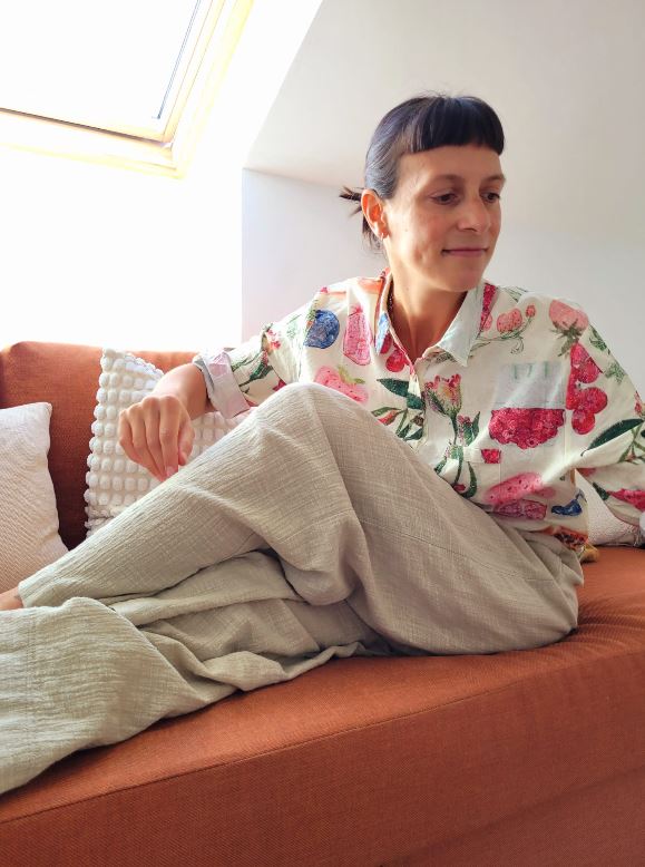Belén Rey recostada en un sofá con camisa de flores